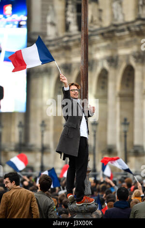 Paris, France. 7 mai, 2017. Un homme brandit une drapeau national français après une estimation a montré que Macron a remporté la course à la présidentielle en face du musée du Louvre à Paris, France, le 7 mai 2017. Candidat centriste Emmanuel Macron a remporté dimanche au second tour de l'élection présidentielle française, en battant son rival d'extrême droite, Marine Le Pen, selon les projections de l'agence de sondage publié après le vote. Une estimation par la firme de recherche Elabe pour BFMTV montrent que Macron a remporté la présidentielle avec 65,9  % des votes, tandis que Le Pen a obtenu 34,1 pour cent. Crédit : Chen Yichen/Xinhua/Alamy Live News Banque D'Images