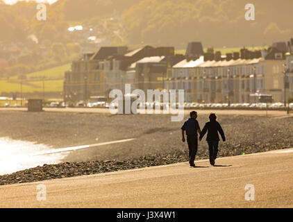 Comté de Conwy, Pays de Galles, Royaume-Uni. 8 mai, 2017. Météo France, soleil sur la côte ouest de la France aujourd'hui, y compris le Nord du Pays de Galles. - Un couple se tenant la main et de prendre une promenade le long de la promenade au nord du Pays de Galles populaires ville côtière de Llandudno Crédit : DGDImages/Alamy Live News Banque D'Images