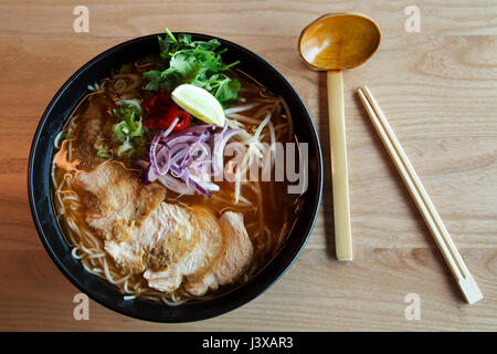 Un bol de chili nouilles poulet servi avec des légumes. Nouilles Ramen est un plat asiatique. Banque D'Images