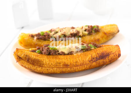 Plantain mûres cuites au four farcies de viande hachée, d'olive, poivron vert et l'oignon, parsemées de fromage, un plat traditionnel en Amérique centrale Banque D'Images