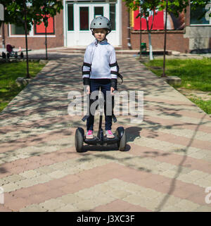 Petite fille triste circonscription mini électrique hoverboard Banque D'Images