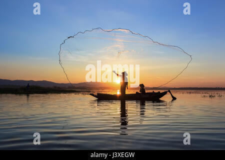 Bateau de pêche pêcheur sur silhouette net réglage avec Sunrise Banque D'Images