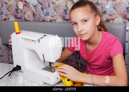 Fille apprend à coudre sur une machine à coudre électrique Banque D'Images