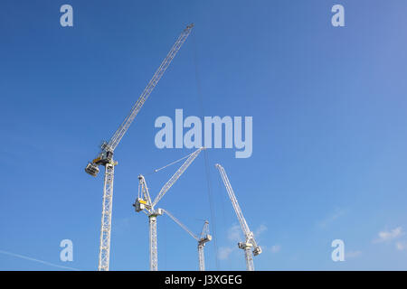 Tall white tower crane contre le ciel bleu Banque D'Images