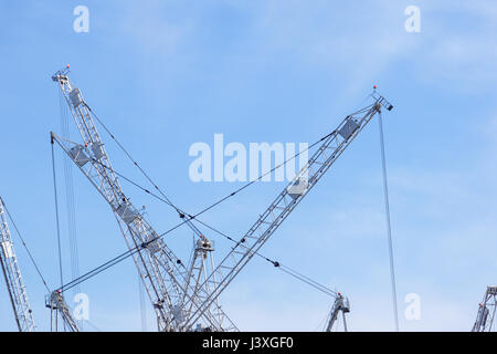 Tall white tower crane contre le ciel bleu Banque D'Images