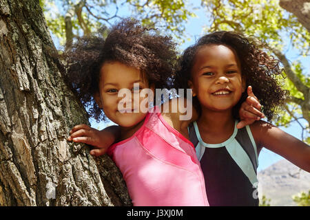 Portrait de deux jeunes sœurs, climbing tree Banque D'Images