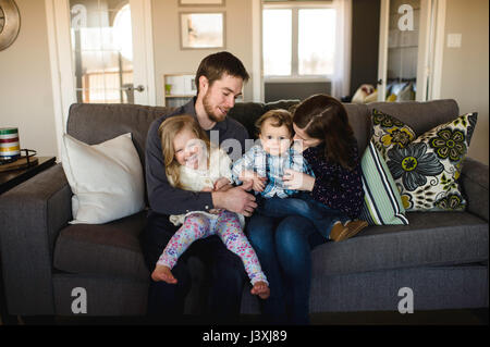 Portrait of mid adult parents avec bébé fille et garçon sur canapé Banque D'Images