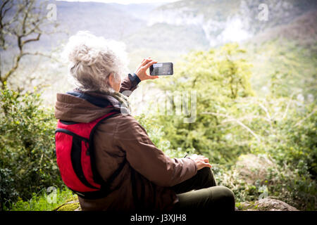 Femme hiker photographing view, Bruniquel, France Banque D'Images