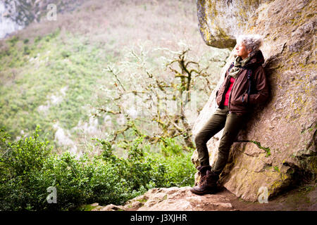 Woman leaning against rock à la vue, à Bruniquel, France Banque D'Images