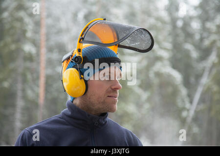 Logger wearing safety visière en forêt, Tammela, Forssa, Finlande Banque D'Images