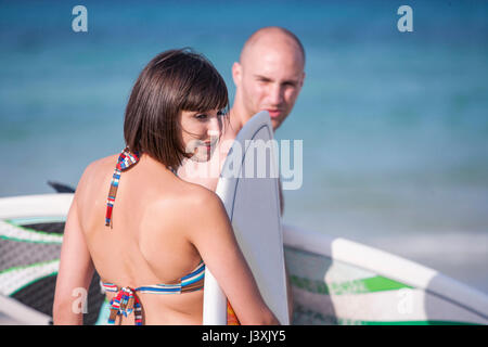 Couple avec des planches de surf de seaside, Mallorca, Espagne Banque D'Images