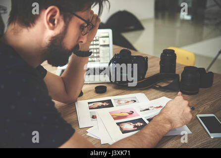 Photographe à la recherche a souligné à des photographies en studio de photographie Banque D'Images