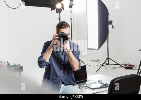 L'accent sur l'essai mâle photographe en studio de photographie reflex numérique Banque D'Images