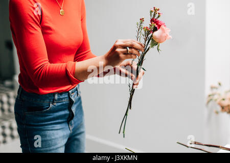 Mid section of female florist holding coupées en atelier les fleuristes Banque D'Images