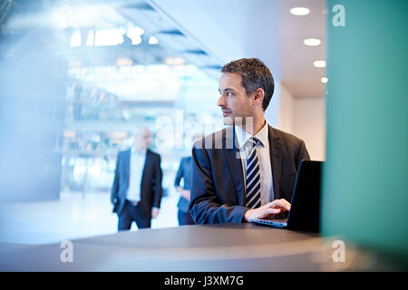 Businessman regardant par-dessus son épaule dans office Banque D'Images