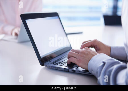 Mains de businessman typing on laptop at office desk Banque D'Images