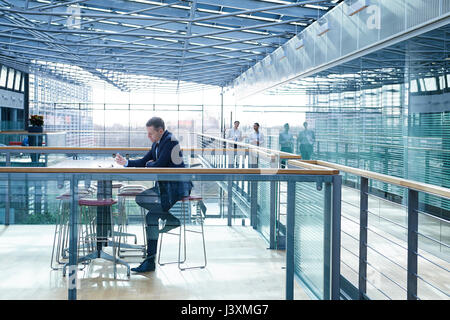 Businessman doing paperwork assis à table balcon bureau Banque D'Images