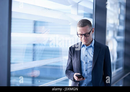 Businessman looking at smartphone in office Banque D'Images