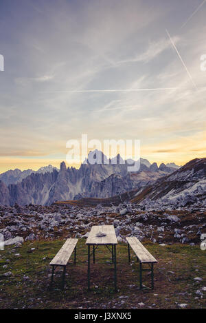 Banc de pique-nique dans le magnifique paysage alpin au coucher du soleil. La montagne dans l'arrière-plan est Monte Cristallo, Dolomites italiennes. Banque D'Images