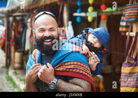 Homme avec kid au Pérou d'avoir du plaisir avec le marché des vêtements d'alpaga Banque D'Images