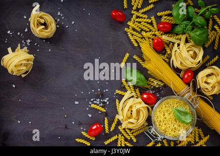 Différents types de pâtes au basilic sur la cuisine table en bois. Banque D'Images
