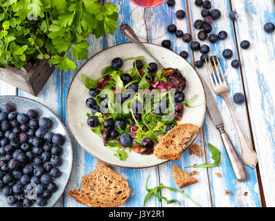 Salade saine avec rocket et les bleuets sur une table d'extérieur. Banque D'Images