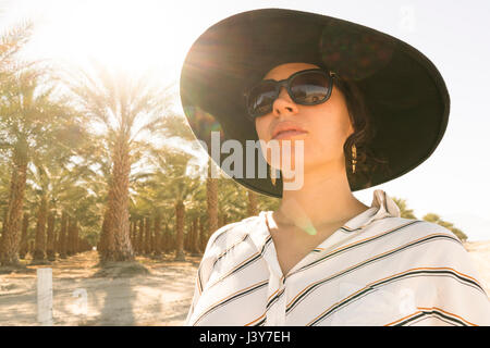 Portrait de femme portant des lunettes de soleil et chapeau à la voiture, Palm Springs, California, USA Banque D'Images