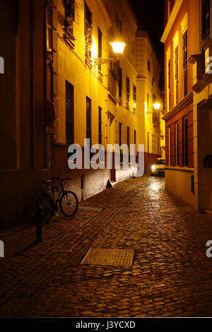 Ruelle pavée avec voiture conduite de nuit, Séville, Espagne Banque D'Images