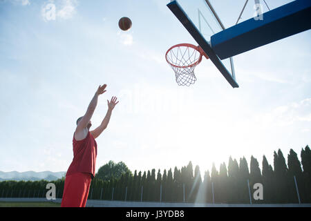 Jeune homme de saut et de faire un fantastique jeu slam dunk stree Banque D'Images