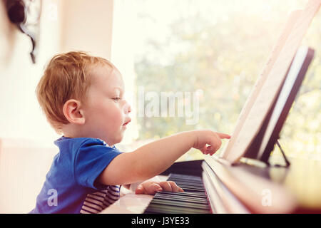 Boy toddler pointing at partition piano à Banque D'Images