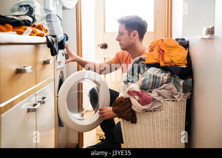 Homme faire la lessive à la maison Banque D'Images