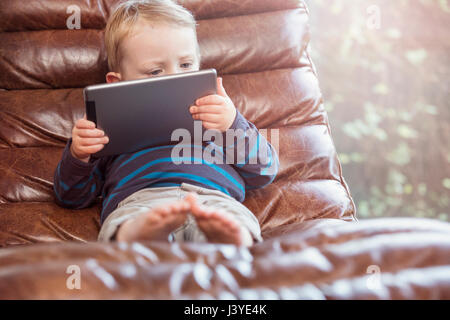 Bébé garçon vous coucher sur un président à la tablette à Banque D'Images