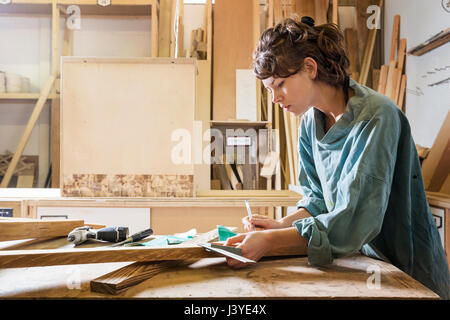 Jeune femme dans un atelier bois de mesure Banque D'Images