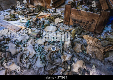 Vieux masques à gaz et cartouches filtrantes à l'école secondaire no 3 dans la ville fantôme de Pripyat de centrale nucléaire de Tchernobyl en Ukraine, la zone d'Aliénation Banque D'Images