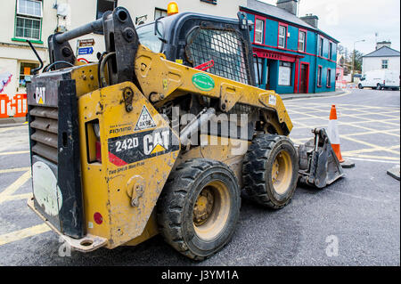 Caterpillar CAT 242D Chargeur compact à Schull, rue Main, Schull, West Cork, Irlande au cours des travaux avec l'exemplaire de l'espace. Banque D'Images