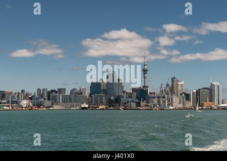 Auckland, Nouvelle-Zélande - 3 mars, 2017 : plan large de la ville vu de l'eau océan verdâtre sous ciel bleu avec quelques nuages blancs. Tours, Banque D'Images