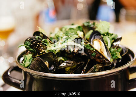 Moules au vin blanc et l'ail avec des frites et de la bière l'accent sur la table d'un restaurant à Bruxelles Banque D'Images