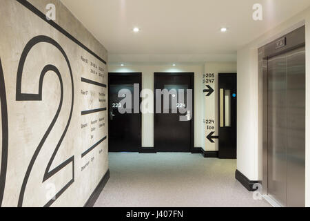 La signalisation dans la zone du corridor de l'ascenseur. Ace Hôtel Shoreditch, London, Royaume-Uni. Architecte : EPR Architects Limited, 2016. Banque D'Images