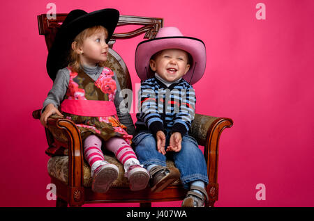 Deux enfants sourire portant des chapeaux de cow-boy, Studio Banque D'Images