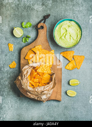 Croustilles de maïs mexicain et sauce guacamole frais sur planche de bois Banque D'Images