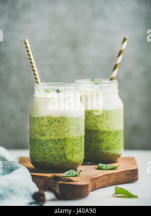 Ombre verte en couches des smoothies avec paille dans des bocaux en verre Banque D'Images