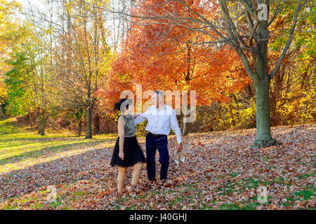 Jeune couple amoureux se tenant la main et marcher dans un parc sur une journée ensoleillée d'automne Banque D'Images