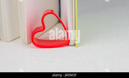 Coeur rouge entre les pages d'un livre journal ouvert Banque D'Images