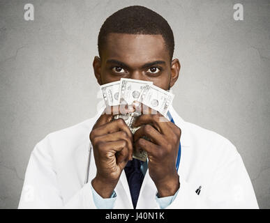 Closeup portrait avide avare grincheux professionnel de la santé, male doctor holding, protéger son argent dollars dans la main, fond noir isolé. Banque D'Images
