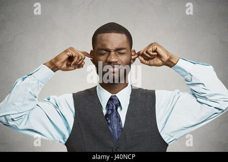 Closeup portrait malheureux, homme ennuyé de brancher les oreilles de clôture avec les doigts, dégoûté d'ignorer quelque chose de ne pas vouloir entendre quelqu'un side story, isoler Banque D'Images