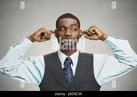 Closeup portrait malheureux, homme ennuyé de brancher les oreilles de clôture avec les doigts, dégoûté d'ignorer quelque chose de ne pas vouloir entendre quelqu'un side story, isoler Banque D'Images