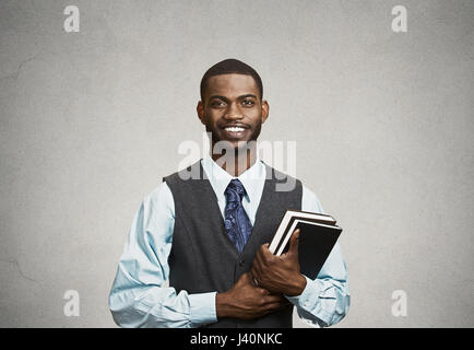 Libre jeunes smart, heureux, smiling handsome man holding books, préparé, prêt à ace son essai examen finale, isolé, noir sur fond gris. Positif Banque D'Images