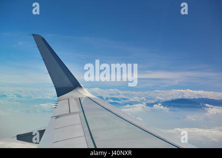 Close-up of air aile d'avion volant sous paysage de montagne sur Ciel clair Banque D'Images