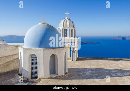 L'une des nombreuses chapelles typiques de l'Eglise orthodoxe grecque sur l'île grecque de Santorin Thira avec vue sur la mer Égée et l'île inhabitée de Nea Kameni je Banque D'Images