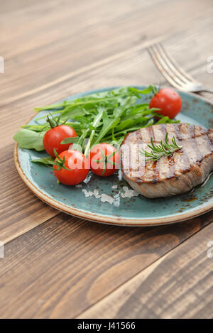 Steak grillé avec rukkola et tomate cerise sur fond de bois Banque D'Images